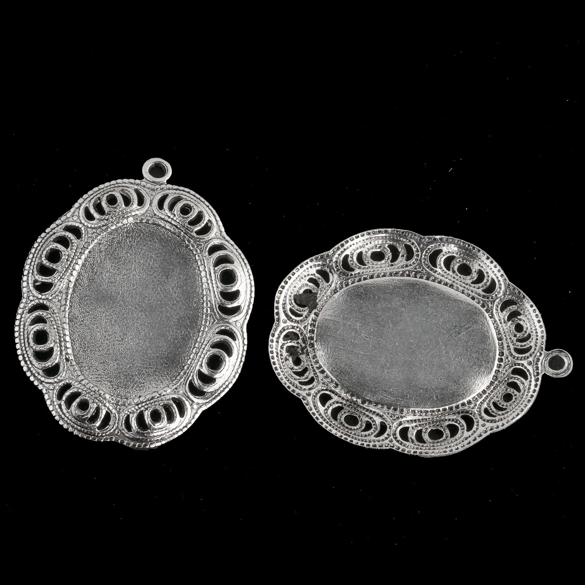 Sterling silver plated brass oval solid back setting for 19x13mm cabochon. Wavy filigree border. 1 ring. Sold individually. b9-2426